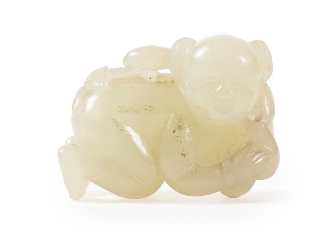A Chinese white jade figure of a crouching boy, 19th/20th century